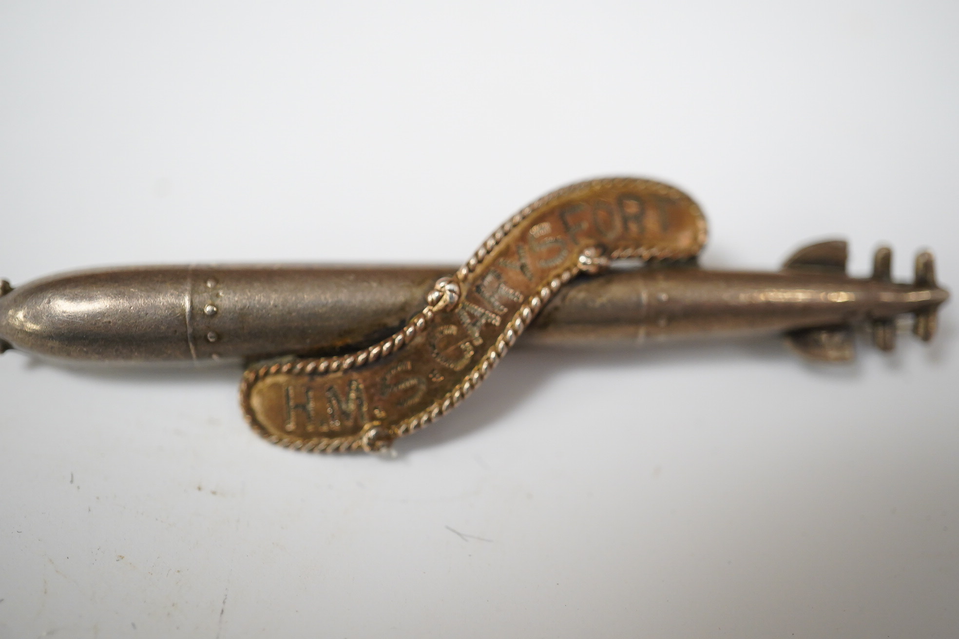 A WW1 silver sweethearts brooch from HMS Caryfort modelled as a torpedo